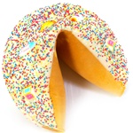 White chocolate covered giant fortune cookies decorated with pink and yellow and blue sprinkles.